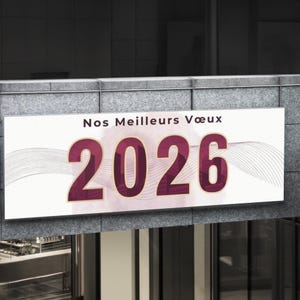 May include: A rectangular sign with the text "Nos Meilleurs Vœux 2026" in burgundy and gold. The sign is mounted on a gray stone wall, with a blurred background of a building.
