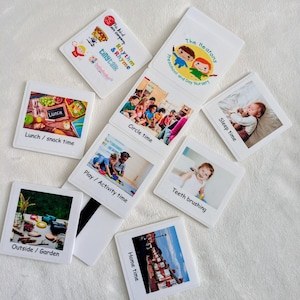 May include: A set of white square magnetic tiles featuring various daily activity labels and photos, including Lunch/snack time, Circle time, Sleep time, Play/Activity time, Teeth brushing, Outside/Garden, and Home time, with a nursery logo.