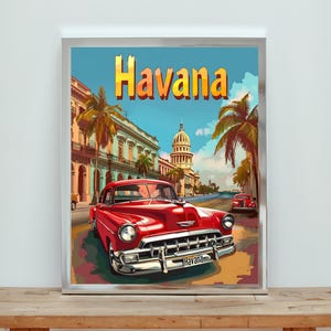 May include: A framed art print featuring a vintage red car driving down a street in Havana, Cuba. The word "Havana" is displayed in large, yellow letters above the car. Palm trees and buildings line the street, with a blue sky and clouds in the background.
