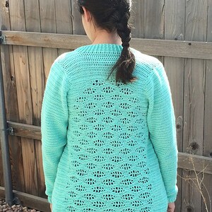 May include: A teal crochet sweater with a lacy openwork design on the back.