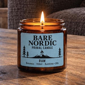 Peut inclure: Une bougie allumée dans un pot en verre brun avec une étiquette bleu clair. L'étiquette indique BARE NORDIC PRIMAL CANDLE RAW, Beeswax, 100ml, Burntime +20h, avec un graphique noir représentant une montagne, une flamme et des sapins.