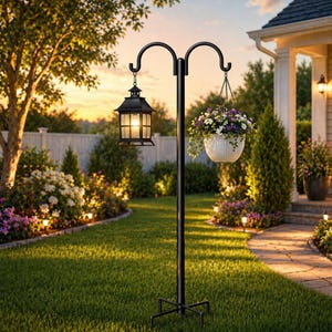 May include: A black metal garden pole with two shepherd hooks. One hook holds a black rectangular lantern with a glowing light, and the other hook supports a white hanging planter filled with purple, white, and yellow flowers and green foliage.