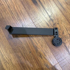 Puede incluir: Un soporte negro para ordenador de bicicleta. Tiene un brazo rectangular con un soporte y un accesorio circular. Dise&ntilde;ado para sujetar un ordenador de ciclismo, est&aacute; hecho de material negro mate. Mide unos 15 cm de largo.