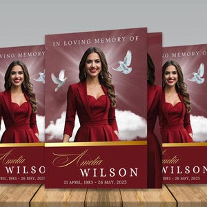 May include: A memorial card design featuring a woman in a red dress and blazer, with the text "In Loving Memory Of" at the top. The name "Amelia Wilson" is displayed in elegant script, along with the dates 1983-2025. White doves and a soft light background are also present.