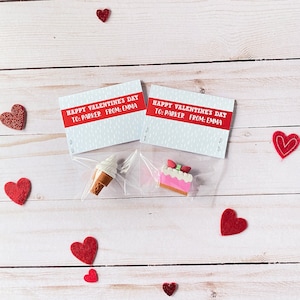 May include: Two small Valentine's Day gift bags with a red and white card that says "Happy Valentine's Day to: Parker From: Emma". One bag contains a small ice cream cone eraser and the other contains a small pink cake eraser.