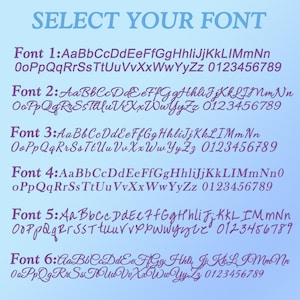 May include: A digital chart titled SELECT YOUR FONT displaying six distinct purple font styles against a light blue gradient background. Each numbered row features the full uppercase and lowercase alphabet followed by the numbers 0 through 9.
