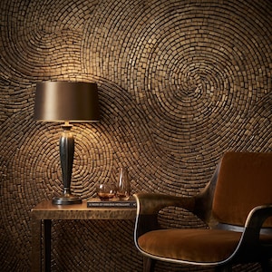 Puede incluir: Una lámpara de mesa con base metálica oscura y pantalla cilíndrica sobre una mesa rectangular junto a un pequeño cuenco de cristal y un libro titulado U NOOK OF HIGH-END METALLURGY. Un sillón de terciopelo marrón se sitúa frente a una pared texturizada.