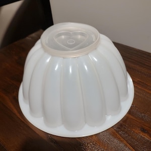 Two vintage Tupperware gelatin molds with one JEL-N-SERVE serving base, and four seals