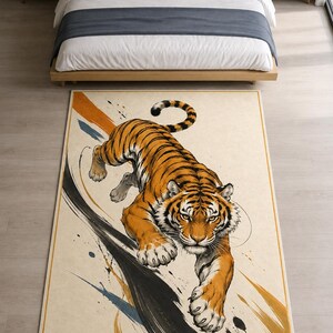 May include: A rectangular area rug featuring a detailed illustration of a tiger in a pouncing position. The tiger has orange fur with black stripes and is set against a cream background with abstract black, orange, and blue brushstroke accents.