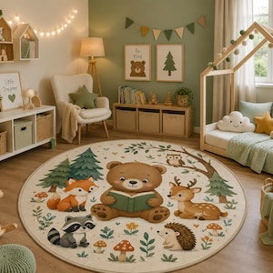 May include: A round area rug featuring a central illustration of a brown bear reading a green book, surrounded by a fox, a raccoon, a deer, and a hedgehog in a forest setting with pine trees, mushrooms, and flowers on a cream-colored background.
