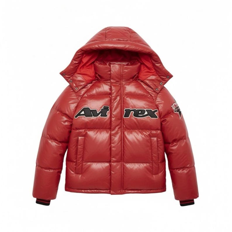 Puede incluir: Una chaqueta acolchada roja brillante con capucha. La chaqueta presenta el texto "Avi Rex" en blanco y negro en el pecho. La chaqueta tiene un dise&ntilde;o acolchado y un pu&ntilde;o a rayas negro y rojo.