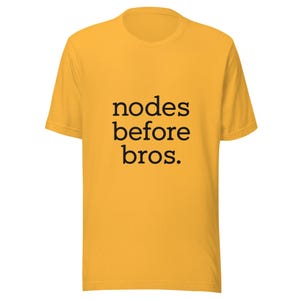 Puede incluir: Camiseta de color amarillo mostaza con la frase "nodes before bros" en negro en el centro. La camiseta tiene mangas cortas y cuello redondo.