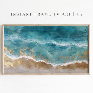 以下が含まれることがあります： 抽象的なビーチシーンを描いた額入りのアートプリント。 ターコイズとゴールドの色調で、白い波と砂浜が特徴です。「INSTANT FRAME TV ART | 4K」の文字が上部に表示されています。