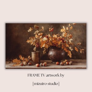 Pu&ograve; includere: Un'opera d'arte per Frame TV con una natura morta. Un vaso marrone scuro contiene rami con foglie arancioni e bacche rosse. Ghiande e un piccolo contenitore di metallo su una superficie di legno. Testo: "FRAME TV artwork by [mizuiro studio]"