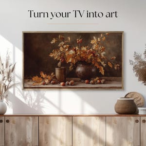 Pu&ograve; includere: Un'opera d'arte incorniciata con una natura morta con un vaso di foglie e bacche autunnali. L'opera d'arte &egrave; in una cornice di legno ed &egrave; esposta sopra un mobile di legno. Il testo "Turn your TV into art" &egrave; nella parte superiore dell'immagine.