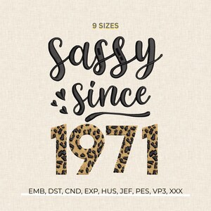May include: An embroidered design with the words "Sassy Since 1971" in black script and leopard print. The design includes small heart shapes. The text "9 Sizes" is at the top.