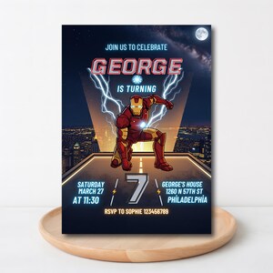 May include: A birthday party invitation featuring the text "JOIN US TO CELEBRATE GEORGE IS TURNING". The invitation includes an illustration of Iron Man, the number 7, and event details: Saturday, March 27 at 11:30, George's House, 1260 N 57th St, Philadelphia.