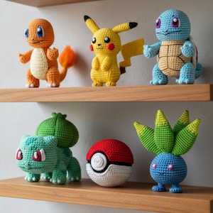 May include: Crocheted Pokémon characters, including Charmander, Pikachu, and Squirtle, displayed on wooden shelves. Other characters include Bulbasaur, a Poké Ball, and Oddish. The handmade figures are in bright colors.