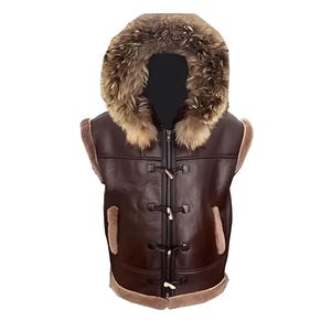 May include: A brown leather vest with a fur-lined hood. The vest features toggle closures down the front and fur trim along the edges. The vest is sleeveless and has a warm, winter-ready appearance.