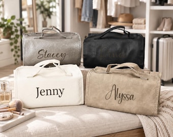May include: Four rectangular toiletry bags with top handles, each featuring a unique name printed in a script font. The bags are available in metallic silver, black, cream, and tan, all displaying a textured finish with the names Stacey, Jenny, and Alyssa.