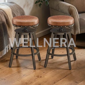 May include: Two industrial-style bar stools. Each stool has a round, brown leather seat with a metal rim. The base is made of dark metal with a footrest. The word "WELLNERA" is printed on the stools.