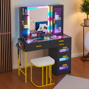 May include: A modern black vanity with a lighted mirror and storage cabinet. The vanity has yellow accents, including the legs and drawer pulls. A white stool sits in front of the vanity. The mirror and cabinet have colorful LED lights.