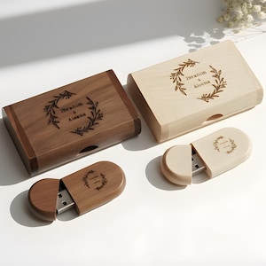 May include: Wooden USB flash drives and matching boxes. The boxes and drives are engraved with the names "Ibrahim & Aiseena" inside a wreath design. One box is dark brown, the other is light wood. The USB drives are in matching colors.