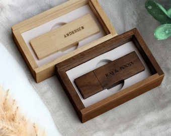 May include: Two wooden USB flash drives in matching wooden boxes. One box is light-colored with the name "ANDERSON" engraved on the USB drive. The other box is dark-colored with the names "RAJ & POOJA" engraved on the USB drive. Both USB drives are rectangular.