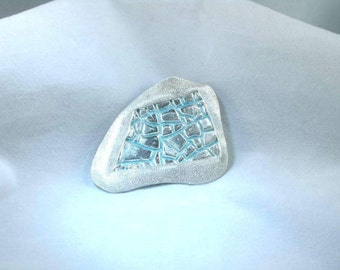 Silver, irreguarly shaped shadow box pin with light blue highlights