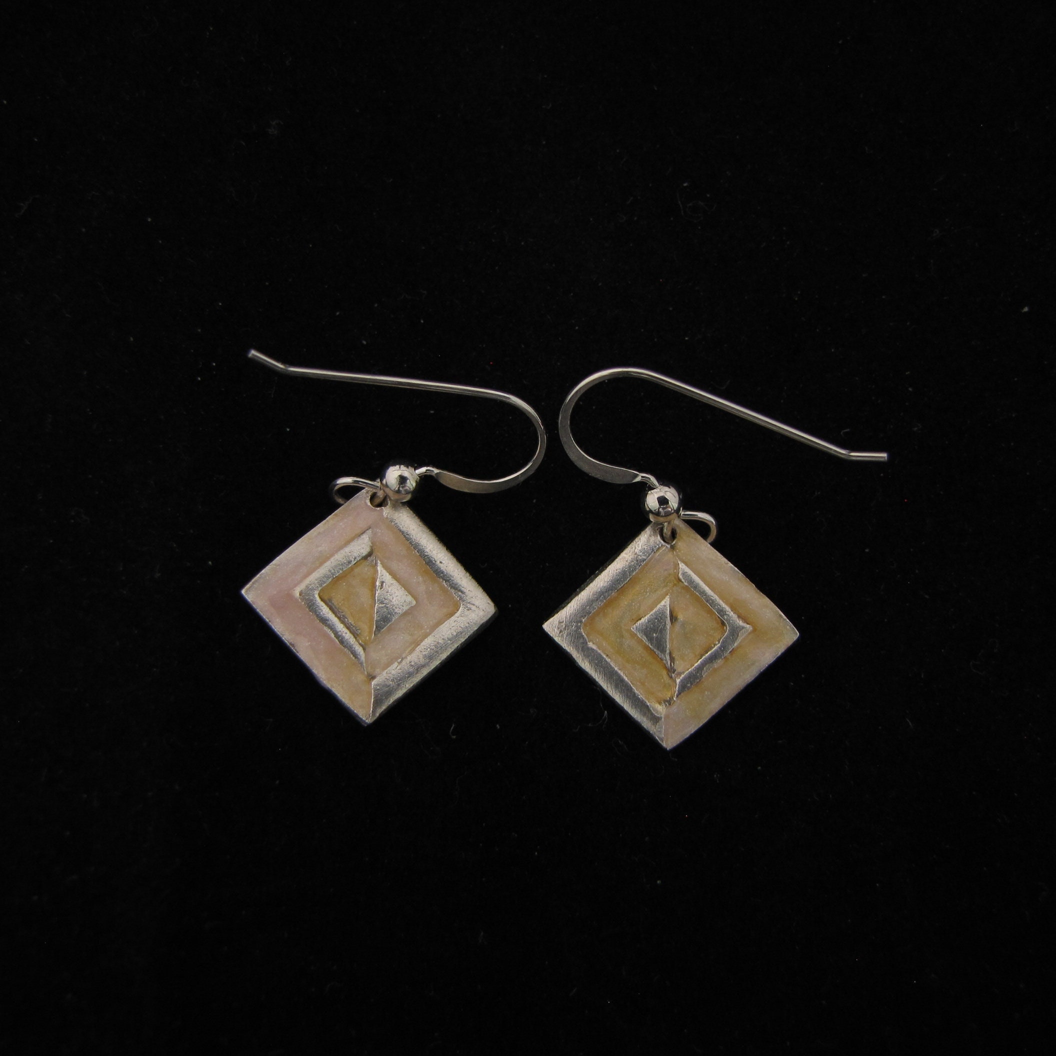 Square silver, wire earrings with a geometric design, highlighted with dark ivory faux enameling
