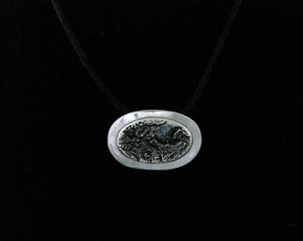 Silver stone textured pendant with muted iridescent patina