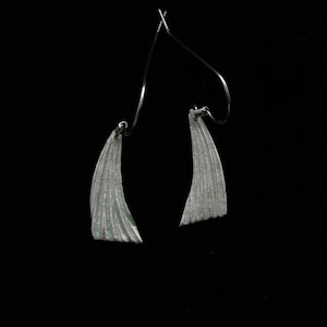 Silver, wing-shaped dangle earrings with light green faux enameling