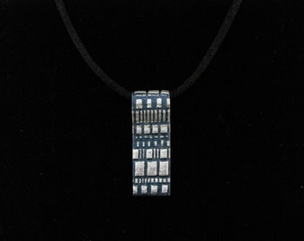 Silver strip pendant with checkered pattern highlighted with dark blue faux enameling