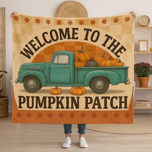 May include: A rectangular blanket with a vintage design. It features a teal pickup truck filled with pumpkins, with the text "WELCOME TO THE PUMPKIN PATCH" in a circular arch. The background is a mix of orange and tan.
