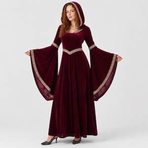 May include: A floor-length burgundy velvet dress featuring a hood, long flared bell sleeves, and a fitted bodice. The garment is accented with intricate gold-toned embroidery along the hood edge, the waistline, and the cuffs of the sleeves.