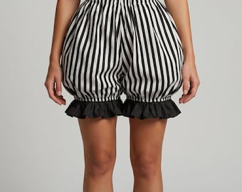 May include: Black and white striped bloomers with a ruffled hem. The shorts have a high waist and a voluminous shape. The vertical stripes are evenly spaced. The bloomers are paired with black boots.