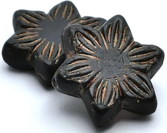 May include: Two dark brown, flower-shaped decorative buttons with carved petal details and a lighter brown accent. The buttons are set against a white background.