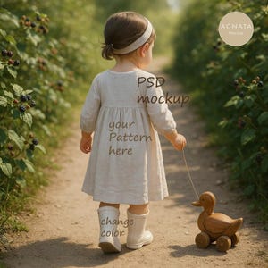 May include: A child wearing a light-colored dress and white boots walks along a dirt path, pulling a wooden duck toy on wheels. The dress has long sleeves and a gathered waist. The image includes the text "PSD mockup", "your Pattern here", and "change color".