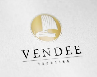 Puede incluir: Logotipo de Vendee Yachting sobre fondo blanco. El logotipo presenta un emblema circular dorado con una ilustración de un velero. Debajo del emblema, la palabra "VENDEE" se muestra en negrita, en negro, con "YACHTING" debajo.