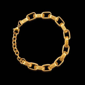 May include: Gold-coloured chain bracelet with a textured, rectangular link design. The bracelet features a lobster clasp closure and an extender chain. The jewellery is displayed against a black background.