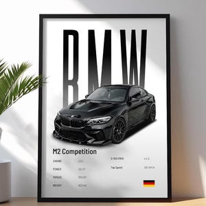 May include: Black framed print featuring a black BMW M2 Competition car. The print includes specifications: 3.0 L engine, 410 HP, 550 Nm torque, and 1825 kg weight. The print also shows the car's 0-100 KM/H time and top speed.