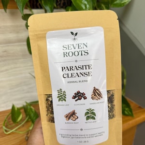 Puede incluir: Una bolsa color canela de mezcla de hierbas Seven Roots Parasite Cleanse. La etiqueta muestra ilustraciones de hoja de orégano, clavo, raíz de diente de león, raíz de bardana y hoja de ortiga. El texto indica 1 oz | 28 g de mezcla.