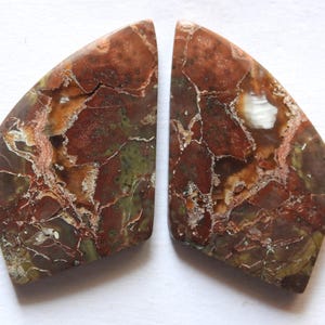 May include: A white ceramic mug with a black handle and the text "But First, Coffee" in a black, bold font. The mug is on a white surface.