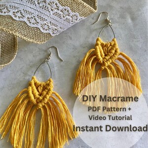 以下が含まれることがあります： 銀色のフックが付いた、黄色のマクラメのイヤリングのペア。イヤリングは上部に織り模様があり、長いフリンジが付いています。画像には「DIYマクラメPDFパターン+ビデオチュートリアルインスタントダウンロード」というテキストも含まれています。