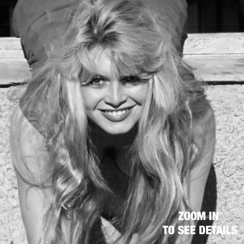 A smiling woman with long, wavy blonde hair is shown in a black and white photograph.