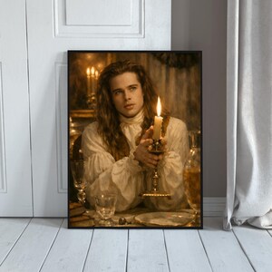 May include: Framed print featuring a portrait of a person with long hair, wearing a white ruffled shirt, holding a lit candle in a decorative holder. The image has a warm, vintage aesthetic with soft lighting and a blurred background.