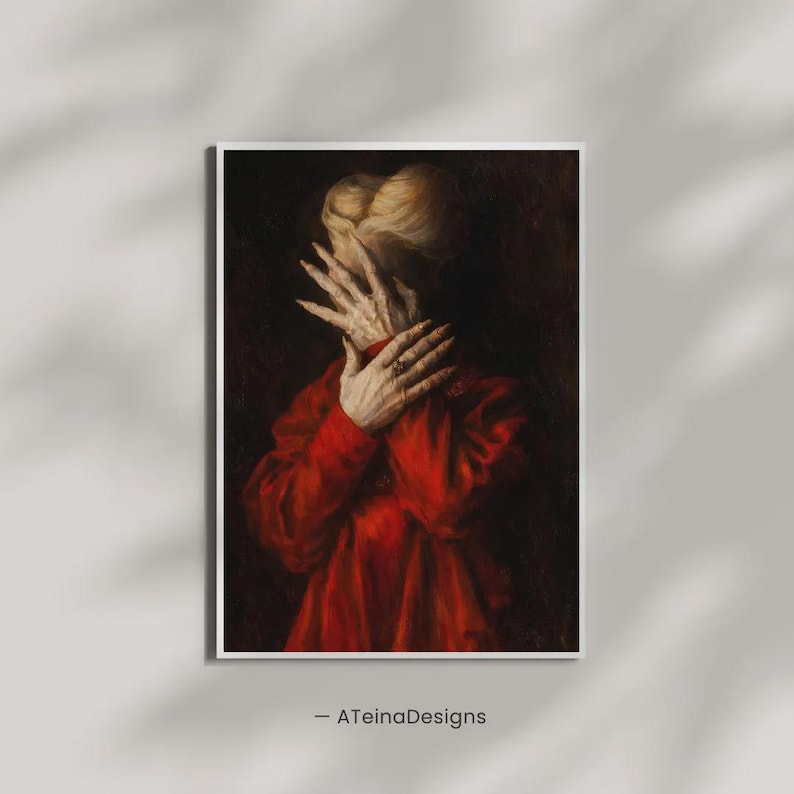May include: A framed art print featuring a person in a red garment, with hands covering the face. The artwork has a dark, dramatic aesthetic, with a focus on the hands and the texture of the fabric. The artist's name, -ATeinaDesigns, is at the bottom.