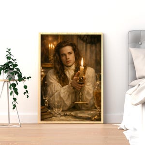 May include: A framed print of a painting depicting a person holding a lit candle. The person has long brown hair and is wearing a white ruffled shirt. The background shows a dimly lit room with a table set for a meal.