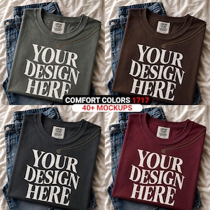 Peut inclure: Quatre t-shirts Comfort Colors de couleurs diff&eacute;rentes : vert olive, marron, anthracite et bordeaux. Chaque t-shirt porte l'inscription blanche "YOUR DESIGN HERE". Les t-shirts sont pr&eacute;sent&eacute;s sur des jeans bleus.