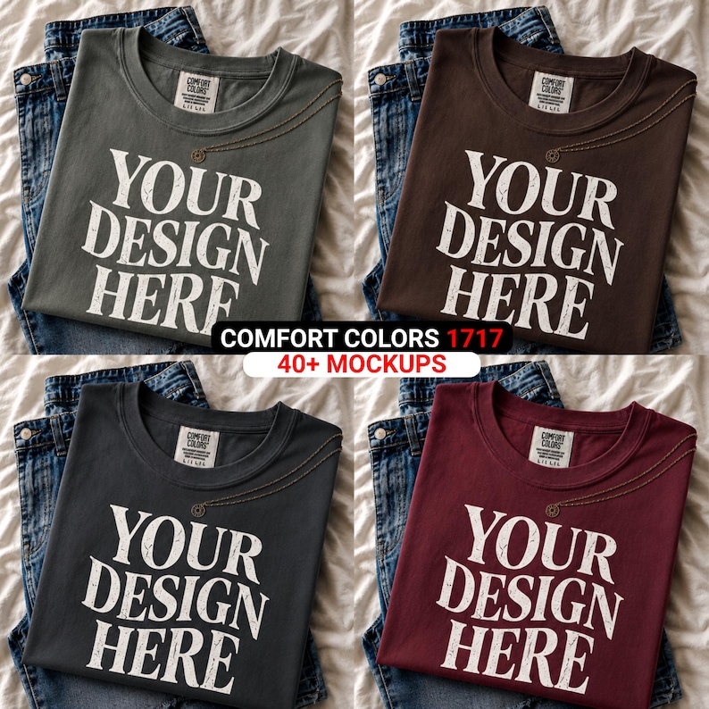 Peut inclure: Quatre t-shirts Comfort Colors de couleurs diff&eacute;rentes : vert olive, marron, anthracite et bordeaux. Chaque t-shirt porte l'inscription blanche "YOUR DESIGN HERE". Les t-shirts sont pr&eacute;sent&eacute;s sur des jeans bleus.